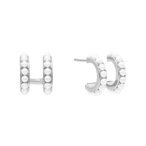 Detail of elegant silver double-row pearl stud earrings with a minimalist semi-hoop design