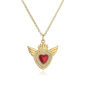 Dettaglio della collana con pendente a cuore e ali dorate con gemma centrale rossa a cuore
