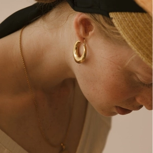 Élégantes créoles épaisses plaquées or 18 carats portées par un mannequin vintage