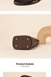 Detail view of the brown monogram bucket bag bottom with four protective gold metal studs