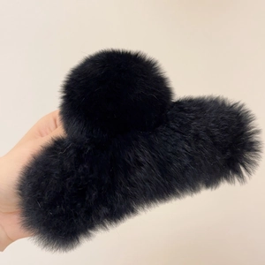 Close-up of black fluffy faux fur hair claw clip showcasing soft texture and large size