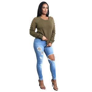 Completo donna con top verde militare cut-out e jeans skinny blu strappati alla moda