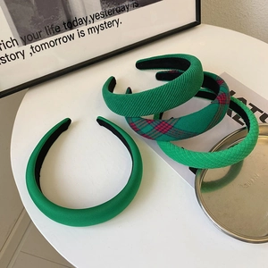 Detailed set of green padded headbands in satin, corduroy, and plaid fabric textures