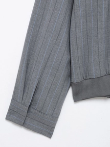 Detailed view of striped varsity jacket with grey fabric and ribbed knitted hem and cuffs