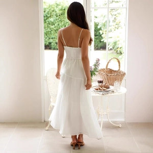 Robe longue blanche dos nu élégante avec volants étagés et design à lacets dans une pièce