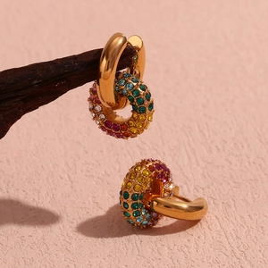 Macro detail of 18K gold earrings with hand-set colorful cubic zirconia crystals