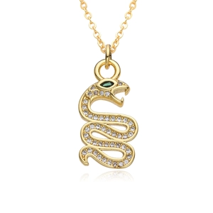Detailed view of a gold snake pendant with clear zircons and green gemstone eye
