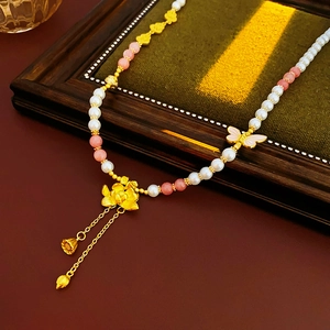 Detail der Vintage-Goldkette mit Lotus-Anhänger, rosa Steinen und weißen Perlenperlen