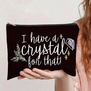 Close-up of black canvas bag with 'I have a crystal for that!' print held by a person