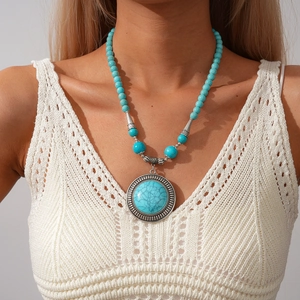 Bohemian turquoise beaded necklace with round engraved silver pendant on model