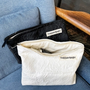 Detail of black and beige rose jacquard canvas cosmetic bags with woven label on fabric
