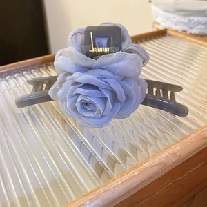 Detailansicht der lila Organza-Rosen-Haarklammer auf einem strukturierten Glastablett