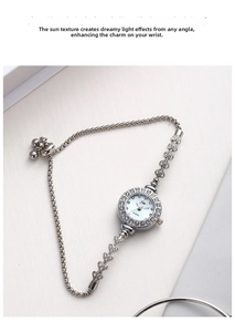 Macro shot of silver diamond-encrusted bracelet watch with heart links and slide clasp