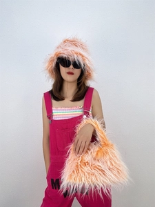 Detail showing the fluffy orange-pink faux fur texture of the hat and matching handbag set