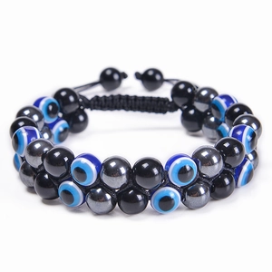 Détail du bracelet tissé double couche avec perles d'oeil de tigre et amulette nazar