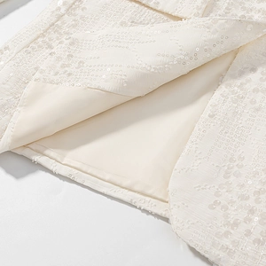 Dettaglio ravvicinato di paillettes color albicocca su blazer con fodera interna premium