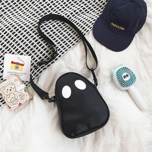 Detail of cute ghost-shaped PU leather crossbody bag with white oval eye accents