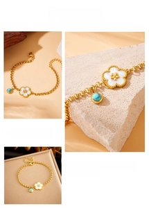 Macro detail of gold-plated stainless steel bracelet with turquoise and shell flower charms
