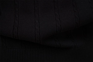 Nahaufnahme von schwarzem Zopfstrickgewebe mit feiner Textur und geripptem Saumdetail