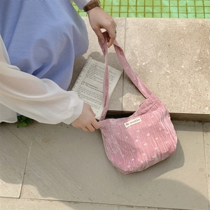 Borsa a mezzaluna in velluto a coste rosa con cuori bianchi in ambiente esterno