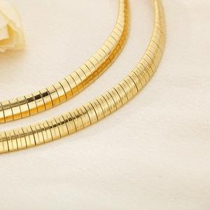 Close-up of polished 18K gold plated herringbone snake chain with smooth metal texture
