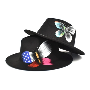 Detailed view of hand-painted butterfly motifs on black wool felt fedora hats