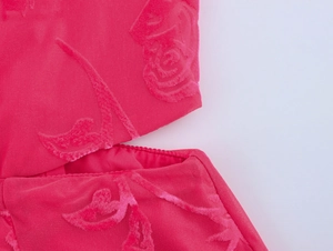 Détail de robe rose avec texture florale 3D floquée et découpe élégante à la taille