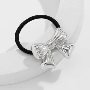 Close-up of silver metal bow with vertical stripes on a black elastic hair tie