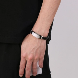 Détail d'un bracelet en cuir tressé à double rangée pour homme avec plaque en métal argenté