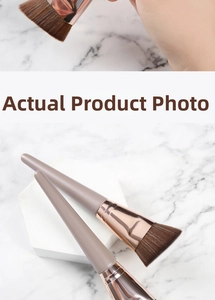 Detail of angled foundation brushes with rose gold ferrules and wooden handles on marble