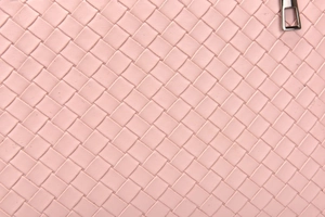 Macro shot of pink woven leather texture with a high-quality metal zipper pull detail