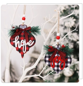 Close-up of wooden Christmas tree ornaments with Hope and Joy lettering on buffalo plaid
