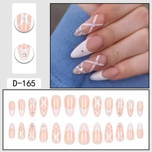 Faux ongles amande French avec motifs de rayures blanches et strass étincelants