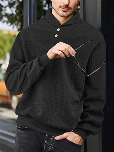 Close-up of black men's hoodie featuring waffle texture fabric and buttoned shawl collar