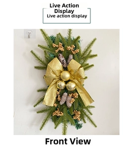 Detail of Christmas teardrop swag with green pine, golden bow, and metallic baubles