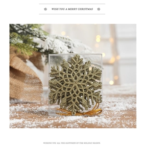Close-up of golden glitter snowflake ornaments in a transparent box with festive decor