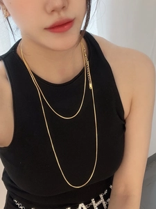 Close-up of 18K gold-plated double-layer square snake bone necklace on model neck