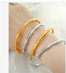 Close-up of bamboo-style gold and silver bangles with polished metallic finish