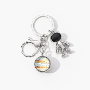 Detailed silver astronaut keychain featuring a double-sided solar system planet pendant