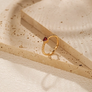 Detail of 18K gold plated beaded ring with a heart-shaped red zircon gemstone