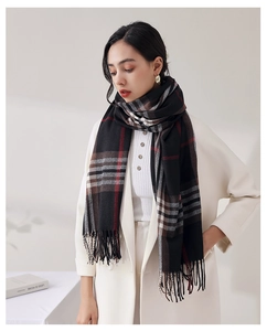 Detail of soft plaid scarf featuring red and black checks with fringed tassels