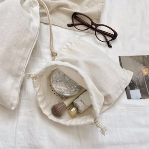 Λήψη flat lay από βαμβακερή τσάντα με κορδόνι, γυαλιά και εργαλεία μακιγιάζ σε ύφασμα