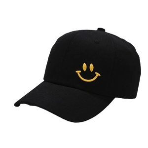 Black baseball cap with yellow embroidered smiley face design on a white background