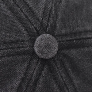 Macro shot of grey corduroy texture with top button and stitched panel details on the cap