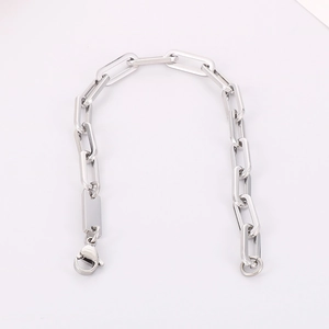 Close-up of silver paperclip chain with rectangle tag and lobster clasp detail
