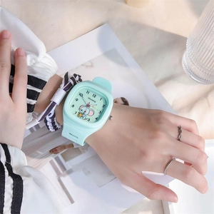 Close-up of mint green square watch with cartoon elephant dial and silicone strap