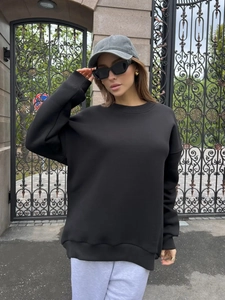 Close-up of thick black crewneck sweatshirt showing high-quality knit texture and seams