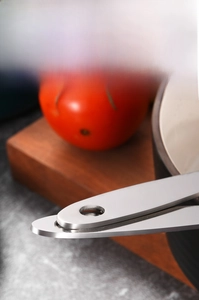 Detail of thickened stainless steel ladle handle with hanging hole and brushed finish