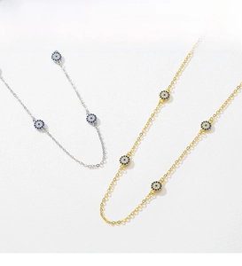 Detail of silver and gold O-chain necklaces with zircon-studded Evil Eye pendants