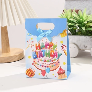 Blue Happy Birthday gift bag featuring cake prints and a light blue silk bow decoration